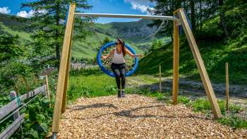 Una donna dondola tra le montagne del Liechtenstein e si gode il panorama