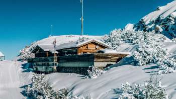 Una donna si gode la vista delle Alpi del Liechtenstein e della Valle del Reno dalla terrazza panoramica di Sareis in una giornata di bel tempo