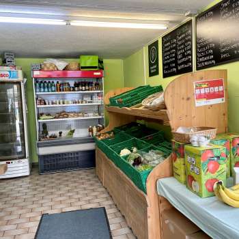  Sala vendita nel negozio della fattoria Aeulehof con verdure fresche, bevande e scaffali refrigerati in Liechtenstein.