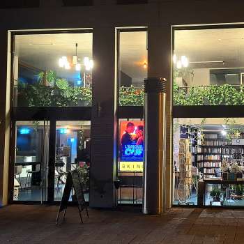 Vista esterna illuminata del cinema Skino di Schaan di notte, con grandi vetrate e un'atmosfera invitante.