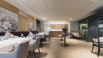 Ampia zona pranzo con un'atmosfera elegante, grandi tavoli e sedute moderne