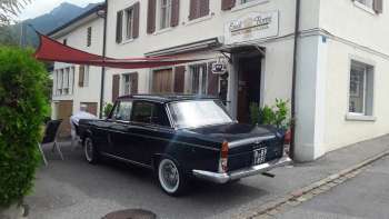 Vista esterna di Eredi Fiorini Gastronomia Italiana con auto d'epoca e invitante area d'ingresso