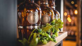 Bottiglie di birra appena spillate su una terrazza soleggiata, circondata da un'atmosfera vivace