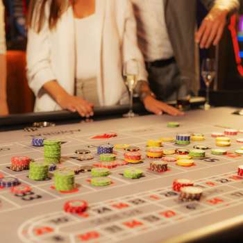 Ospiti al tavolo da gioco che piazzano le loro fiches nel Casinò Admiral Triesen, circondati da un'emozionante atmosfera da casinò.
