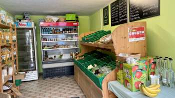  Sala vendita nel negozio della fattoria Aeulehof con verdure fresche, bevande e scaffali refrigerati in Liechtenstein.