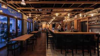 Interni accoglienti del St. Martins Pub con bar elegante e soffitto con travi in legno e illuminazione serale Interni accoglienti del St. Martins Pub con bar elegante e soffitto con travi in legno e illuminazione serale