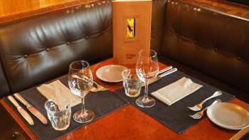 Tavola imbandita con menu nell'area salotto in pelle del Vanini Café