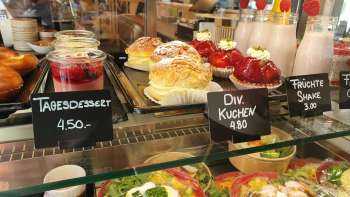 Variegata selezione di torte, crostate e snack freschi nella vetrina del Café 44 Café im Hof