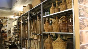 Scaffali con utensili tradizionali, damigiane e oggetti di uso quotidiano