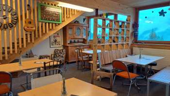 Camera degli ospiti con finestra frontale e decorazione - tavoli e sedie in una stanza aperta con grandi finestre e vista sull'area verde esterna.