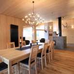 Interni in legno chiaro con tavolo da pranzo e caminetto presso la Haus Ochsenkopf a Malbun, Liechtenstein