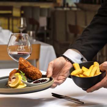 Servito con carne impanata e patatine fritte in una presentazione moderna nel ristorante Alpspitz.