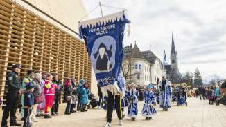Törmleguger Vaduz vestiti a festa durante la sfilata di carnevale a Vaduz, Liechtenstein, davanti al palazzo del governo e alla cattedrale.