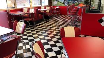 Interno dell'1950 American Diner con tavoli rossi e pavimento in bianco e nero