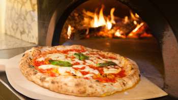 Primo piano di una pizza davanti al forno del Ristorante Pizzeria Sapori Primo piano di una pizza davanti al forno del Ristorante Pizzeria Sapori