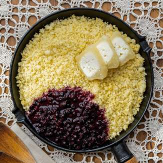 Ribe (Ribe) in padella con burro fuso e mirtilli rossi, servito su una tovaglia all'uncinetto - piatto tipico del Liechtenstein