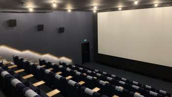 lice del grande schermo cinematografico dello Skino Schaan, con file di comode poltrone dal design scuro.