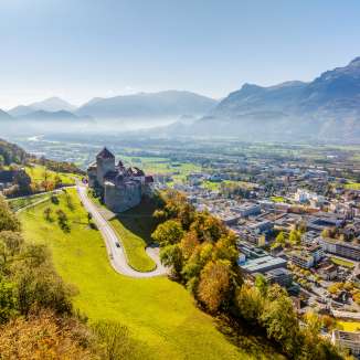 Veduta aerea del castello di Vaduz con vista sulla città di Vaduz e sulla valle del Reno in una limpida giornata autunnale