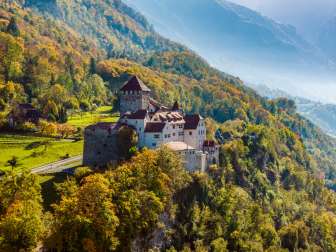 Il castello di Vaduz su una collina boscosa in un paesaggio autunnale nel Liechtenstein