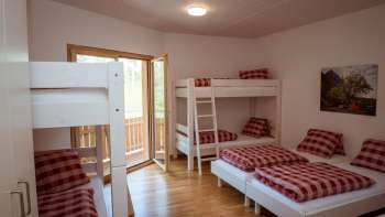 Camera a più letti per famiglie con letti a castello e letti singoli nella guest house del Camping Mittagsspitze.