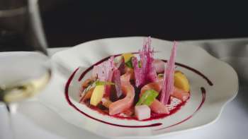 Primo piano di un piatto gourmet con ingredienti freschi, colori vivaci e presentazione creativa