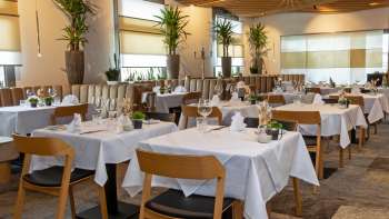 Vista del ristorante Alpspitz, arredato con stile, con tavoli bianchi e un'atmosfera moderna e luminosa.