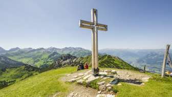 Croce di vetta sul monte Schönberg con montagne e vista sulla valle del Reno sullo sfondo