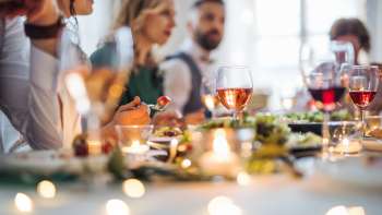 Cena d'atmosfera: le persone si siedono insieme a una tavola imbandita a festa e si godono la cena.