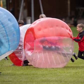 I bambini giocano a bubble soccer all'aperto: divertimento e azione in un'avventura all'aperto in Liechtenstein