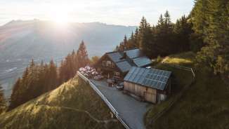 Ripresa panoramica di una remota baita di montagna nel Liechtenstein con vista sulla valle del Reno e tecnologia solare sul tetto