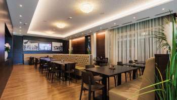 Elegante sala del Restaurant Kommod con disposizione simmetrica e atmosfera accogliente.