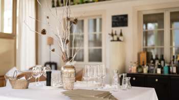 Il bar del ristorante Vivid è decorato con bicchieri, bottiglie e illuminazione naturale.