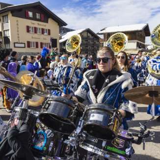 La Guggenmusik in costumi colorati suona alla sfilata del Carnevale 2024 nella nevosa Malbun, nel Liechtenstein.