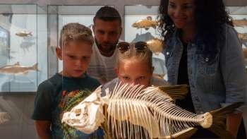 Una famiglia osserva lo scheletro di un pesce al Museo Nazionale del Liechtenstein