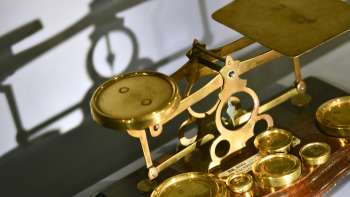 Immagine di un'antica bilancia a fascio color oro con vari pesi, esposta al museo postale del Liechtenstein. Immagine di un'antica bilancia a fascio color oro con vari pesi, esposta al museo postale del Liechtenstein.