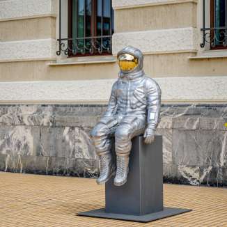 Vista laterale di una scultura di astronauta in argento con visiera dorata alla mostra Bad Ragartz di Vaduz