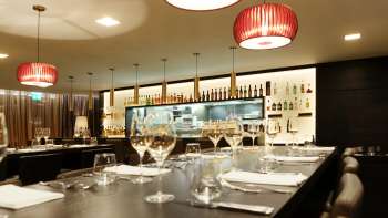 Bar moderno nel ristorante Kokon con eleganti bicchieri da vino e illuminazione d'atmosfera