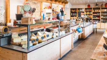 Moderna sala vendite del negozio della fattoria Bangshof in Liechtenstein con prodotti regionali come formaggio, yogurt e frutta.