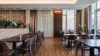 Ristorante moderno Kommod con interni in legno scuro e panche imbottite. Ristorante moderno Kommod con interni in legno scuro e panche imbottite.