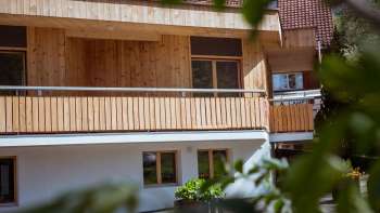 Vista esterna della guest house del Camping Mittagsspitze con facciata in legno e balcone in un ambiente naturale