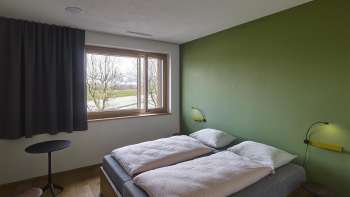Camera doppia con una parete dipinta di verde nell'ostello della gioventù di Schaan-Vaduz