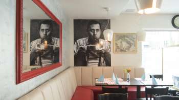 Accogliente salottino nel ristorante Made in Italy un elegante quadro appeso alla parete e uno specchio rosso