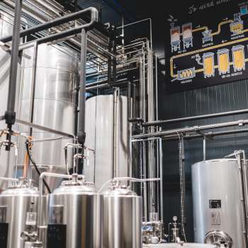 Vista della sala tecnica del birrificio con il suo complesso sistema di tubature e i moderni serbatoi in acciaio inox.