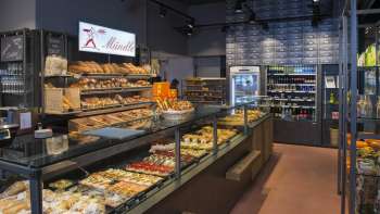 Pane, torte e pasticcini appena sfornati nella moderna panetteria Mündle di Ruggell con un invitante banco di vendita
