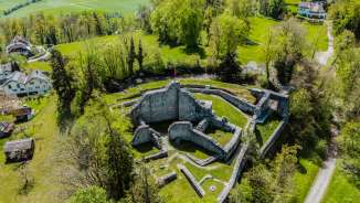 Vista aerea delle rovine del castello di Schellenberg nel Liechtenstein, circondato da una campagna verdeggiante: una meta escursionistica popolare dal fascino storico