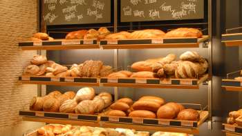 Scaffale pieno di pane e altre prelibatezze presso la panetteria e pasticceria Amann