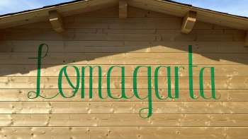 Vista del logo verde Lömagarta, elegantemente impresso sulla facciata in legno dell'accogliente birreria.