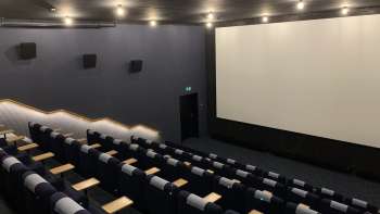 lice del grande schermo cinematografico dello Skino Schaan, con file di comode poltrone dal design scuro.
