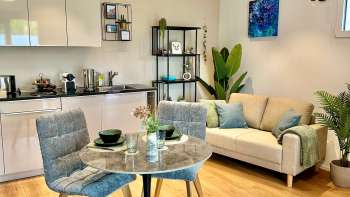 Angolo cottura, tavolo da pranzo e divano