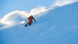 Marco Büchel scia su una pista innevata a Malbun, con la neve che vortica dietro di lui.